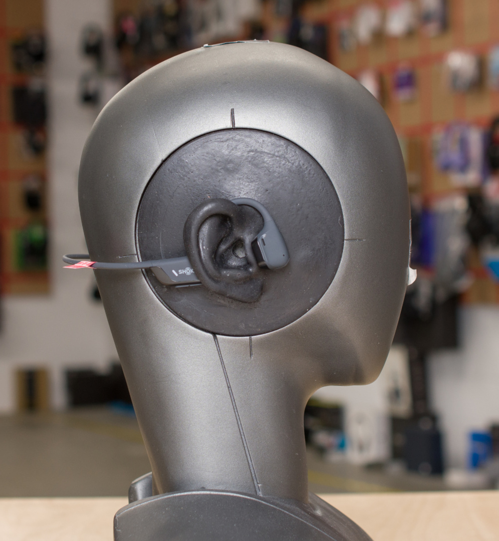 Bone conduction headphones with the transducer placed in front of the ear (the tragus).