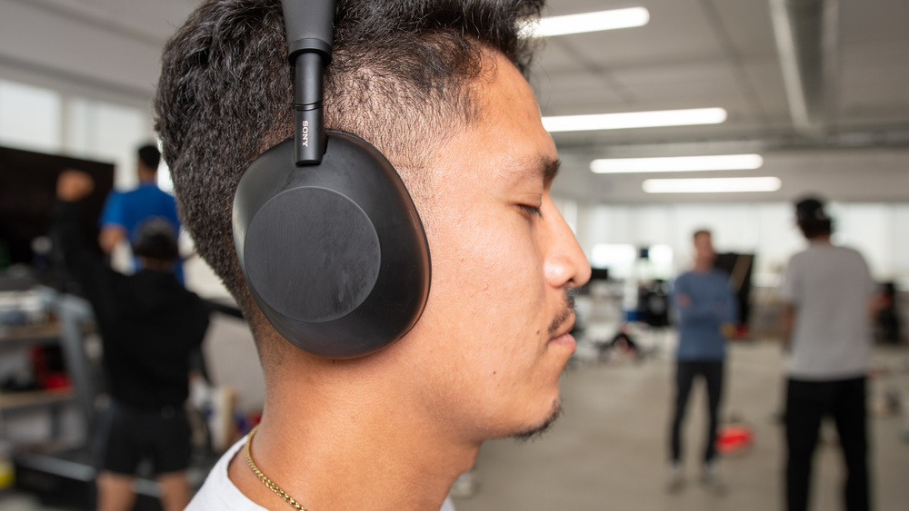 An image of a headphone user in a busy office.