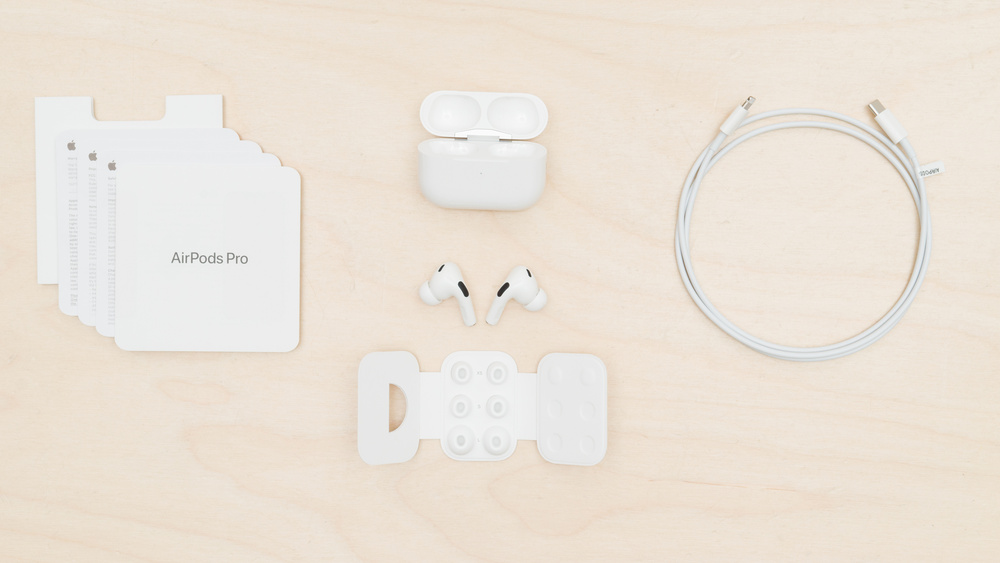 An overhead shot shows all the items in the box when you open the Apple AirPods Pro (2nd generation) box: manuals, ear tips, case, earbuds, ear tips, and cable.