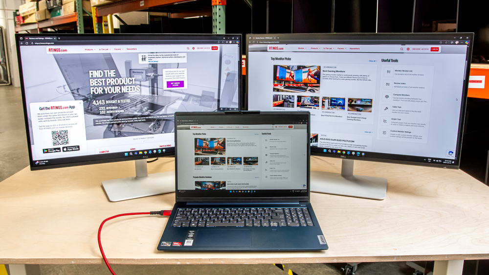A laptop connected to two monitors in a multi-monitor setup.