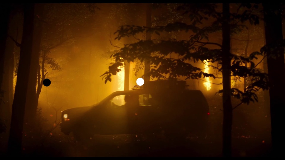 A forest fire scene from the movie Civil War overlayed with two 0.1% APL measurement patches: one white and one black patch.