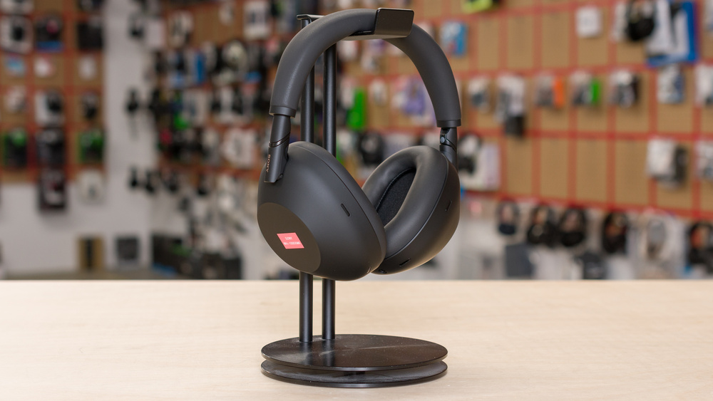 The Sony WH-1000XM6 headphones hanging from a headphone stand.