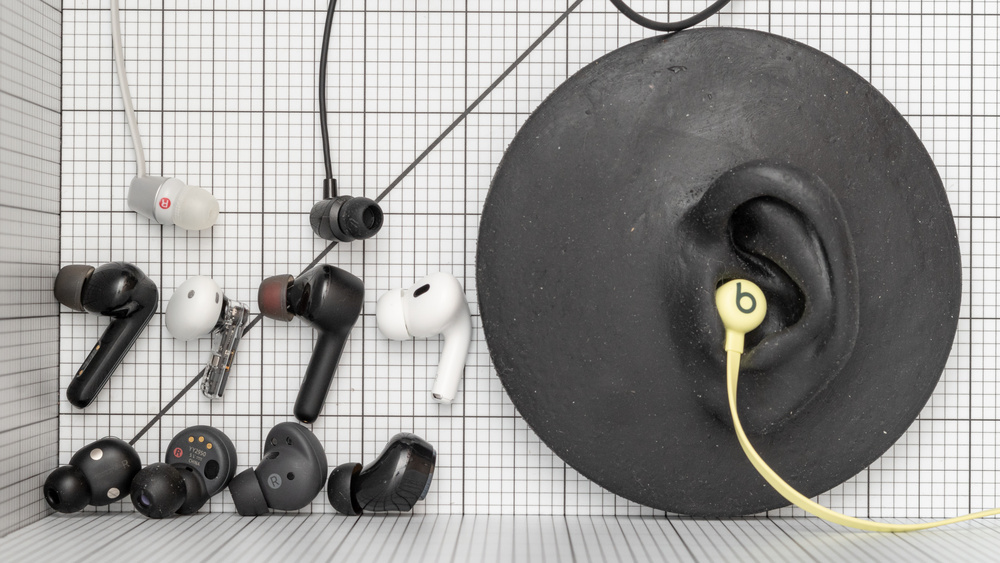 A photo of many earbuds and IEMS that also demonstrates how neckband headphones fit.