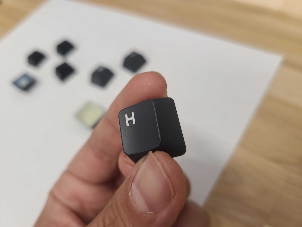 A close-up of a black double-shot ABS keycap from the Drunkdeer A75, with the letter 