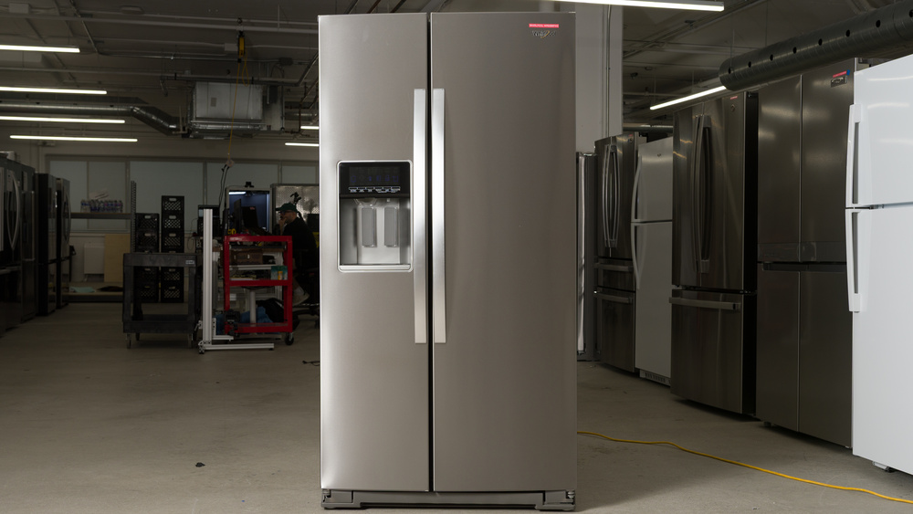 A side-by-side refrigerator in a stainless steel finish with handles on the doors. The doors are full-height, and the door seam is to the left of center. There's a recess for the ice and water dispenser on the left.