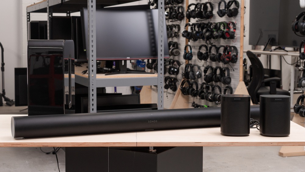 An image of the Sonos Arc with Sub + One SL Speakers set, laid out on a table in the RTINGS office.