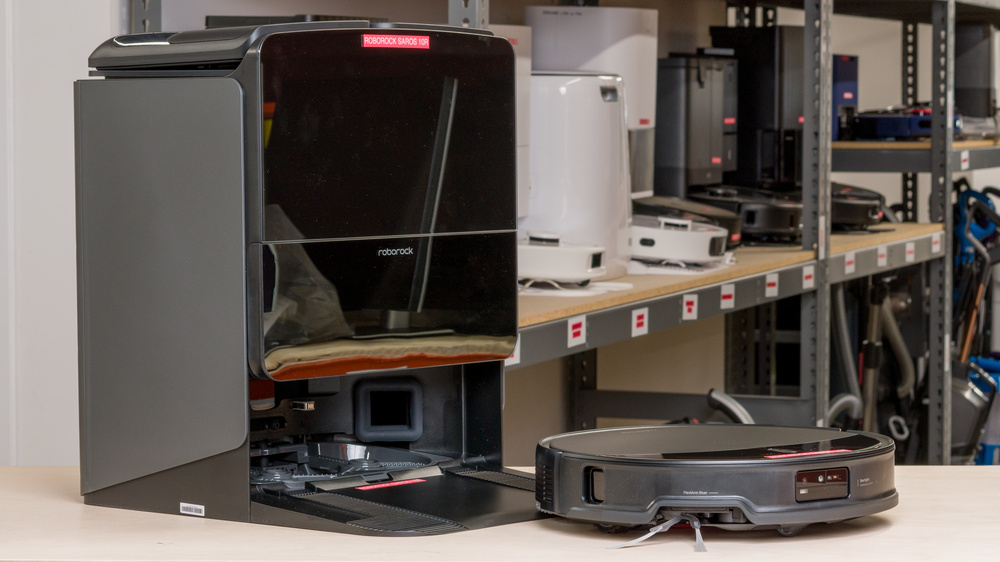 A robot vacuum and its dock on a table in our robot vacuum storage area.
