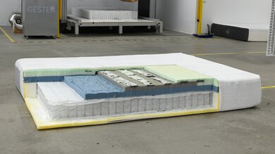 The Casper Snow mattress in a warehouse-like environment, cross-sectioned to show the different layers inside.