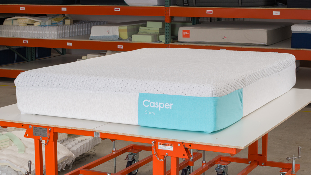 The Casper Snow, a hybrid mattress with excellent cooling performance, on a table in a warehouse setting.