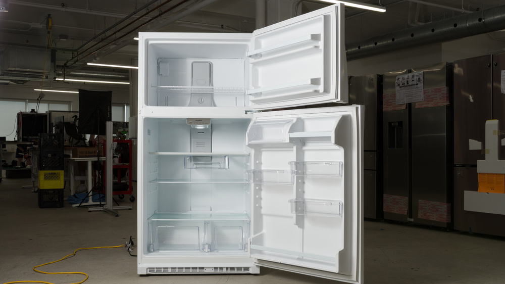 A white top freezer refrigerator with both doors open. In the upper left corner of the freezer there's a small box covering the mounting point of the ice maker.