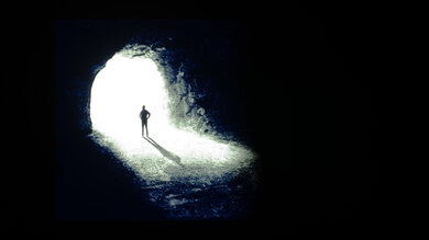 Contrast test photo on the LG C5 OLED showing a man standing at the opening to a cave.